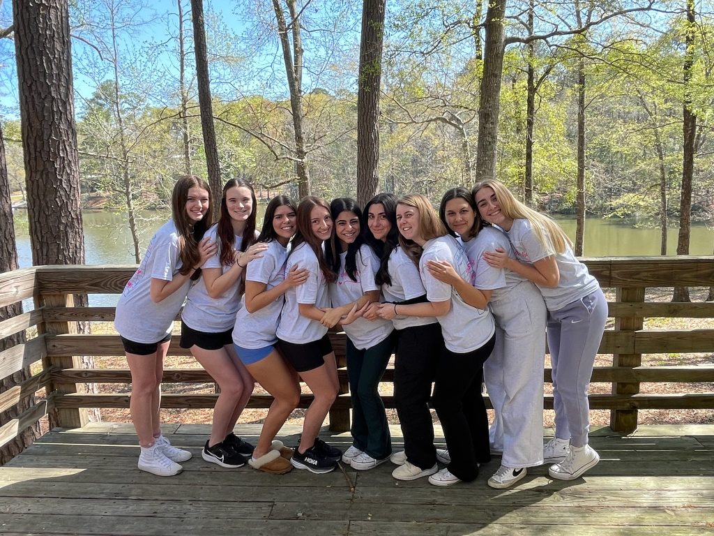 IMG_0090 group of girls standing side by side hugging in wooded backdrop